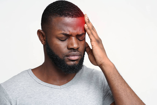 Młody człowiek cierpiący na ból głowy, dotykający czoła - Zdjęcie, obraz
