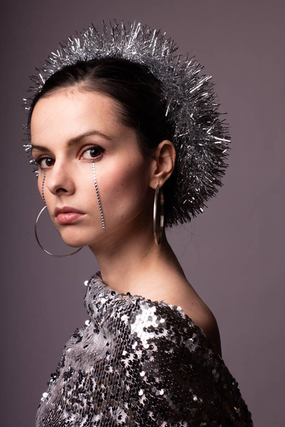 beautiful girl in a best-looking dress, a brilliant rim with rhinestones on her face - Foto, imagen