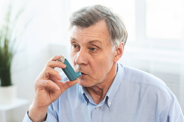 Пожилой человек использует ингалятор от астмы для аллергии
 - Фото, изображение