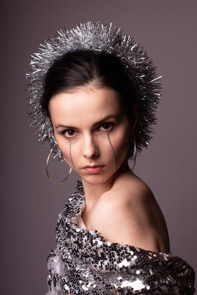 beautiful girl in a best-looking dress, a brilliant rim with rhinestones on her face - Foto, imagen