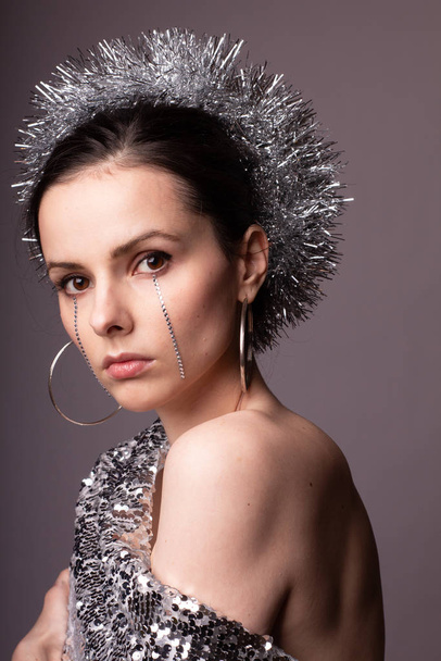beautiful girl in a best-looking dress, a brilliant rim with rhinestones on her face - 写真・画像