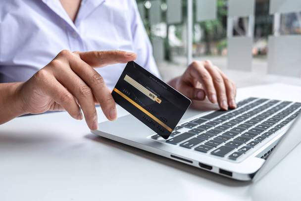 Femme d'affaires utilisant un ordinateur portable et détenant une carte de crédit pour payer d
 - Photo, image