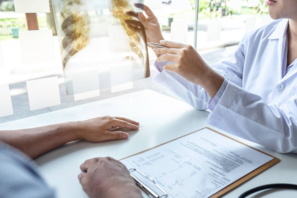 Médico sosteniendo y mirando la radiografía examinando los pulmones radi
 - Foto, Imagen