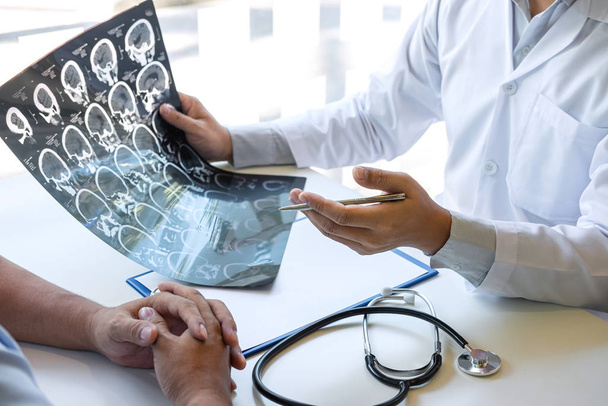 Γιατρός κρατώντας και κοιτάζοντας ακτινογραφία φιλμ που εξετάζει στον εγκέφαλο από c - Φωτογραφία, εικόνα