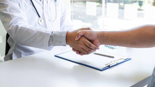 Doctor and patient shaking hands after a good and successful tre - Photo, Image