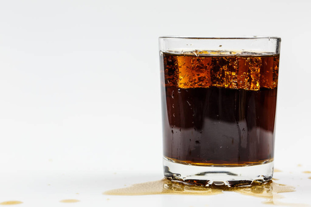 Black soda in a glass with ice on a white background - Fotó, kép