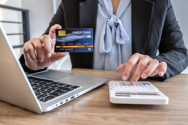 Bizneswoman za pomocą laptopa i posiadania karty kredytowej do płacenia de - Zdjęcie, obraz