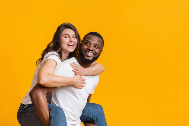 Весёлый чёрный парень подкатывает к своей девушке, межрасовая пара веселится вместе
 - Фото, изображение