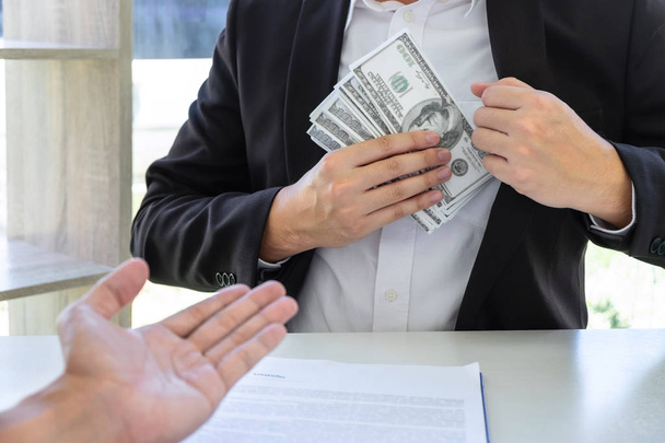 Empresario dando dinero de soborno en el sobre de su pareja
  - Foto, Imagen