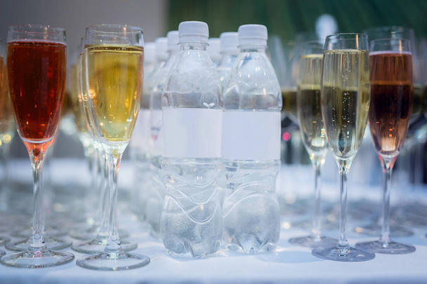 шведский стол на столе есть бутылки чистой воды рядом с бокалами вина красного и белого
 - Фото, изображение