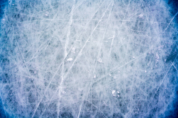 IJs achtergrond met merken van schaatsen en hockey, blauwe textuur van ijsbaan oppervlak met krassen - Foto, afbeelding