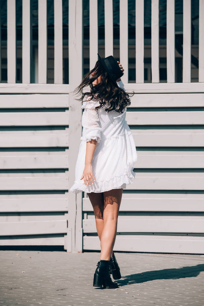 lifestyle portrait of young stylish hipster woman, wearing trendy white dress - Foto, imagen