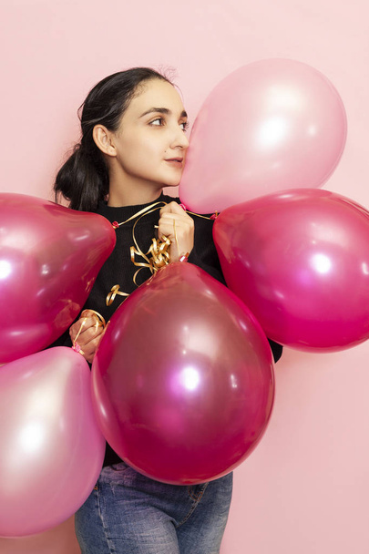 junge hübsche Frau in legerer Kleidung mit festlichen Luftballons. Porträt einer glücklichen Frau aus dem Mittleren Osten, die Valentinstag, Geburtstag, Party feiert - Foto, Bild