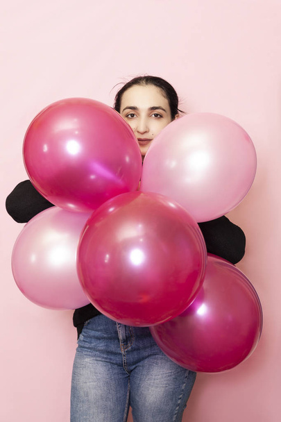 Young pretty woman in casual clothing holding festive air balloons. Portrait of happy 20s middle-eastern female celebrating valentines day, birthday, party - Foto, afbeelding