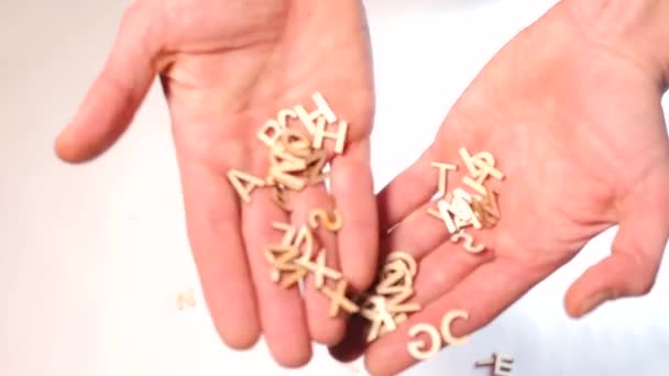 Close-up of the letters of the English alphabet in the palms of a man. - Materiaali, video