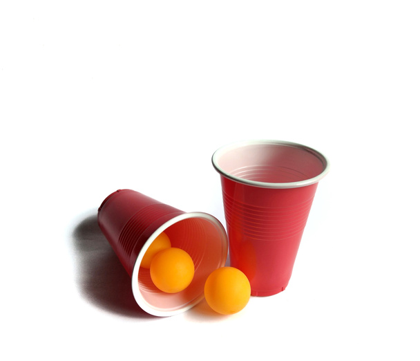 Bicchieri rossi con palline da ping pong su sfondo bianco. partita a beer pong. concetto di partito
 - Foto, immagini