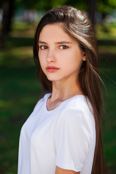 ����������eautiful brunette girl in white t-shirt on a backgroun - Foto, Bild