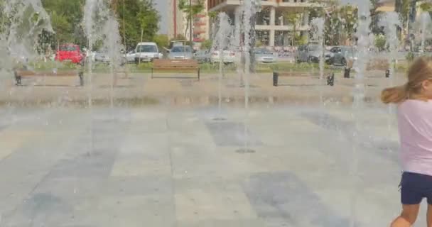 Молода дівчина розважається у фонтані міського парку
 - Кадри, відео