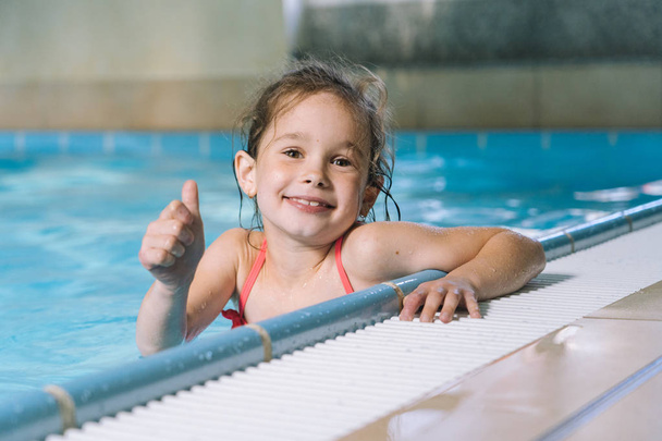Портрет маленькой девочки, развлекающейся в закрытом бассейне
. - Фото, изображение
