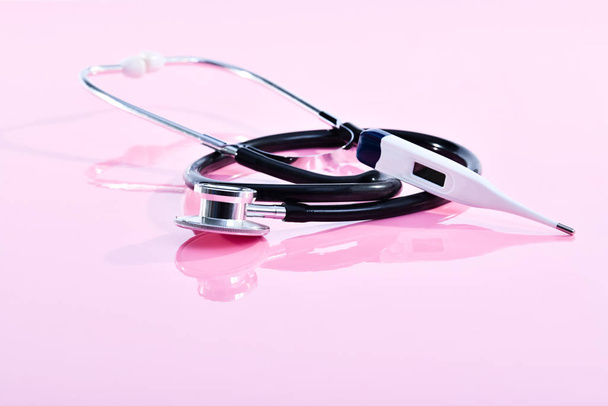 Digital electronic thermometer resting on a stethoscope - Photo, image