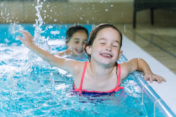 Portrait little girl having fun in indoor swimming-pool. The gir - Photo, Image
