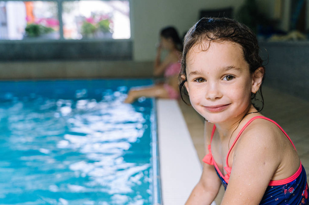 Portret dziewczynki bawiącej się w krytym basenie. Dziewczynę. - Zdjęcie, obraz