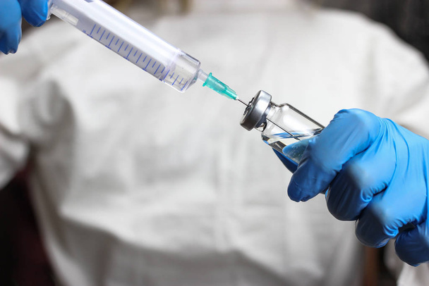 Az egészségügyi dolgozó fecskendőbe tárcsázza a vakcinát - Fotó, kép