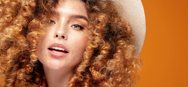 Woman with curly hairstyle and natural freckles. - Foto, Bild