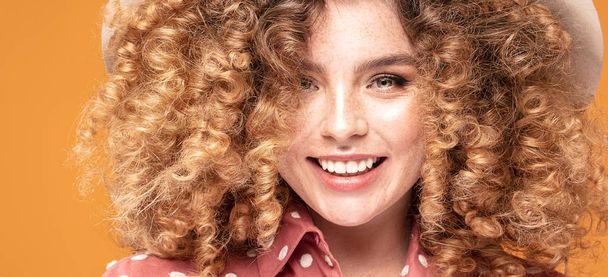 Woman with curly hairstyle and natural freckles. - Foto, Imagen