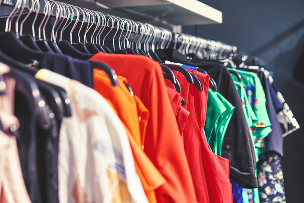 Τα ρούχα κρέμονται σε ένα ράφι σε ένα κατάστημα ρούχων σχεδιαστών. Πώληση ενδυμάτων - Φωτογραφία, εικόνα
