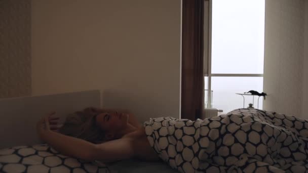 Woman wake up in her bed at the morning - Materiał filmowy, wideo
