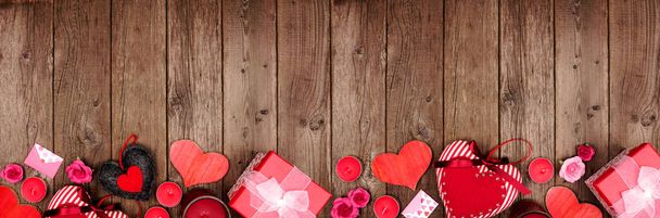 Valentines Day rám s červenými srdci, dárky a výzdobou přes rustikální dřevo pozadí. Horní pohled s mezerou pro kopírování. - Fotografie, Obrázek