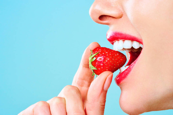Mulher bonita comendo morangos. Imagem ilustra dieta, alimentos saudáveis, bagas e frutas
. - Foto, Imagem