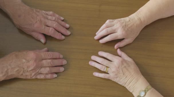 Vista dall'alto di una romantica coppia caucasica anziana che si tiene per mano su un tavolo
 - Filmati, video