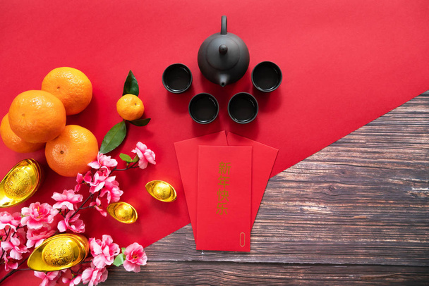 Chinesisches Neujahr mit rotem Umschlag chinesische Teekanne und Orange, Übersetzung des Textes erscheinen in Bild: Frohes neues Jahr, Wohlstand, reich und gesund - Foto, Bild