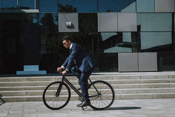 Elegant man riding bike to office stock photo - Foto, Imagem