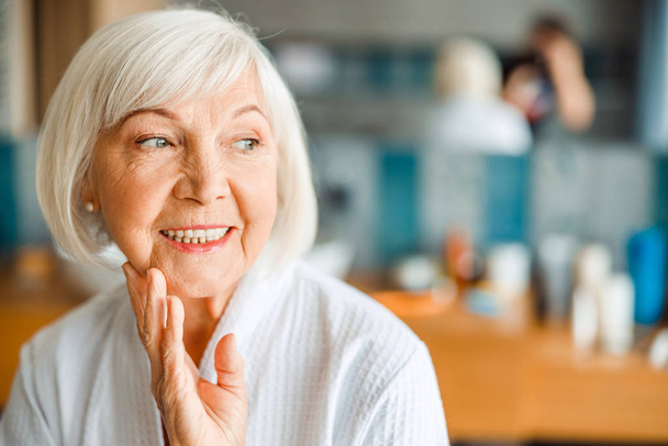 Cheerful old woman looking away and smiling - Фото, зображення