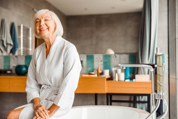 Cheerful elderly woman relaxing in spa salon - Foto, afbeelding