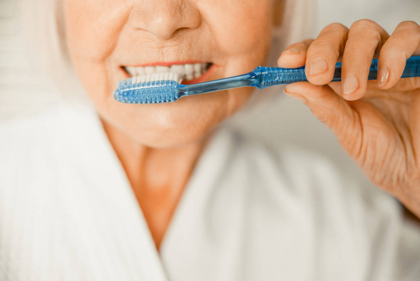 Old woman brushing teeth in the morning - Photo, Image