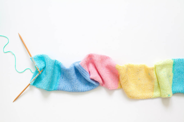 Knitted long scarf in pastel colors. Unicorn style. White backgr - Φωτογραφία, εικόνα