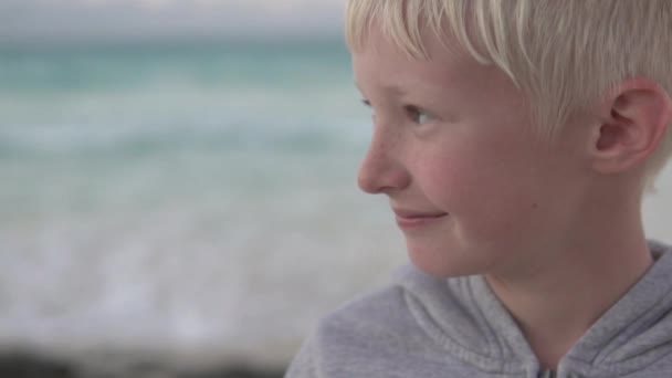 Close-up of a beautiful blonde teenager in the background of the ocean - Footage, Video