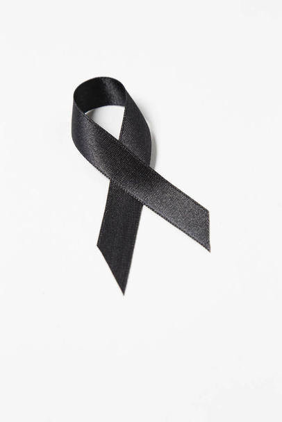 schwarzes Awareness Ribbon auf weißem Hintergrund. Symbol für Trauer, mit Kopierraum. - Foto, Bild