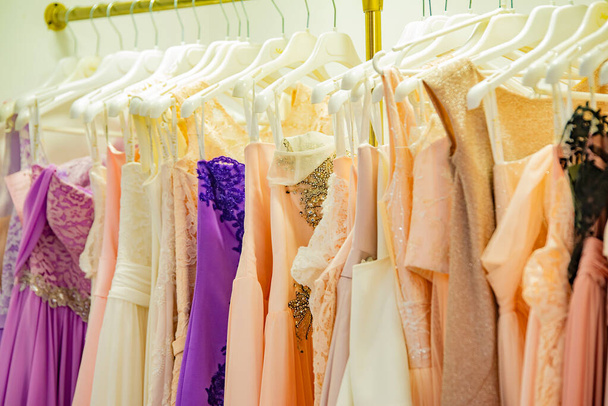 Вечерние элегантные платья на витрине магазина модного бутика и на вешалке магазина на продажу
. - Фото, изображение