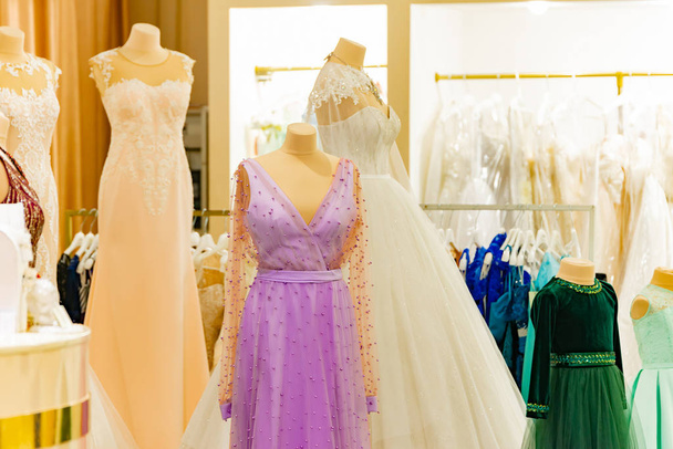 Véspera vestidos elegantes em uma janela de loja de uma butique de moda e em um cabide de uma loja à venda
. - Foto, Imagem