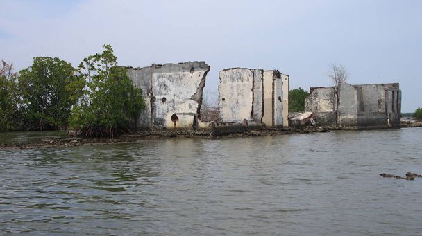 edificios dañados por la exposición al agua de marea en la playa
 - Foto, imagen