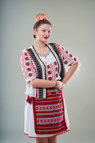 Young Romanian woman in traditional popular costume, studio shot - Foto, imagen