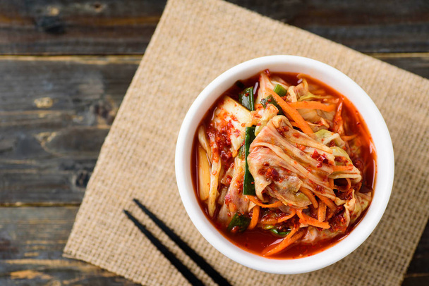 Kimchi zelí v misce s hůlkami, korejské jídlo, pohled shora - Fotografie, Obrázek