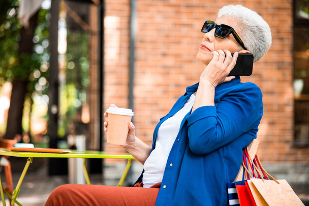 Senior lady having phone conversation on the street - Fotoğraf, Görsel