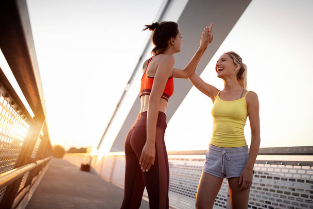 Beautiful fit happy women friends working out, exercising, running, jogging outdoor. - Photo, Image