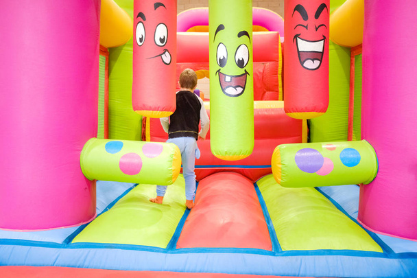 Un niño disfruta saltando y rebotando en un castillo inflable en su
 - Foto, imagen